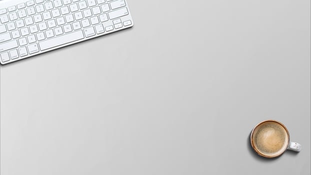 Modern aluminum keyboard on the wooden table in the office with coffee on the table photo