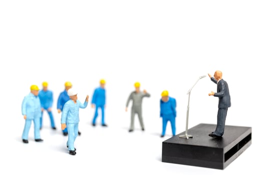 Miniature people listening to a politician speaking during an election rally photo