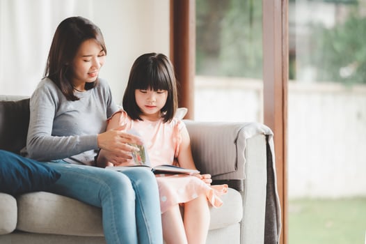 Asian mother and daughter reading a book photo