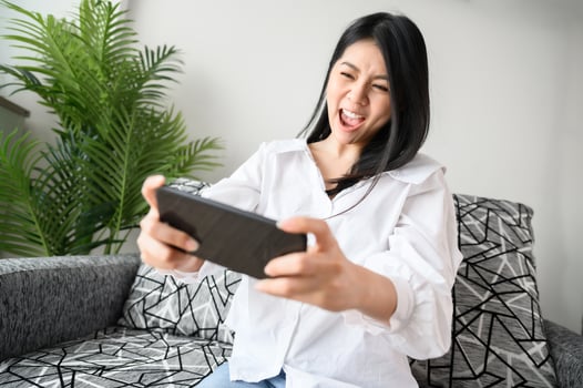 Woman having fun playing game on smartphone photo