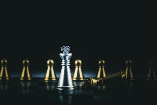 Silver and gold chess pieces on black photo
