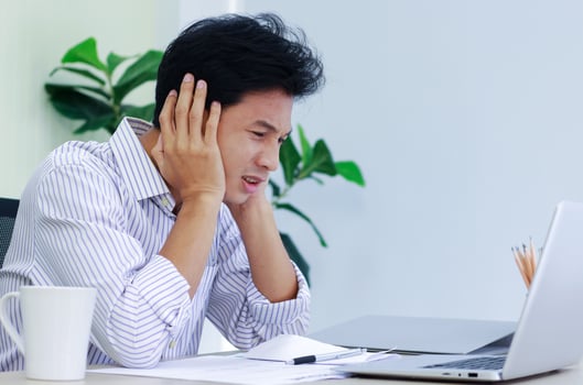 Young businessman stressed at desk photo