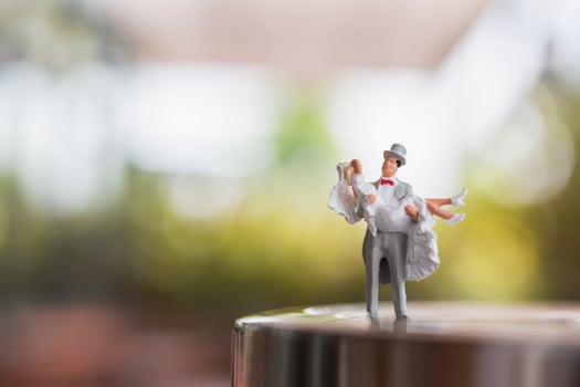 Miniature bride and groom couple standing on a stage, wedding concept photo