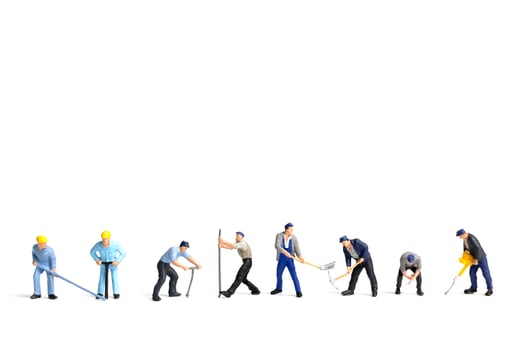 Miniature workers holding tools on a white background, construction concept photo