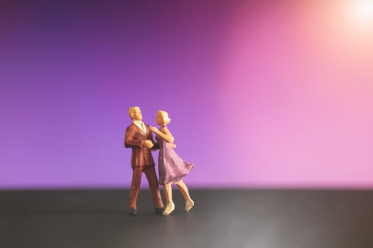 Miniature couple dancing with a colorful bokeh background photo