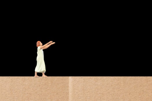 Miniature woman suffering from somnambulism at home on a black background photo