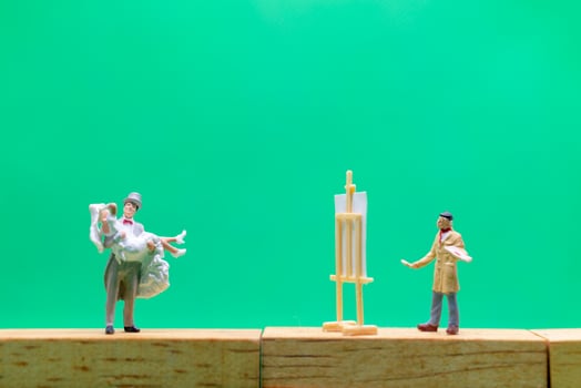 Miniature wedding, bride and groom couple on a green background photo