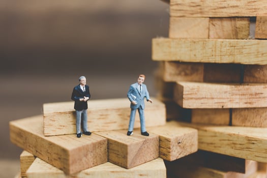 Miniature businessmen standing on woodblocks photo