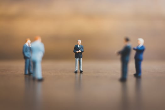 Miniature businesspeople standing on a wooden background photo