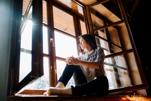 Girl in a house near the window overlooking a snowy landscape photo