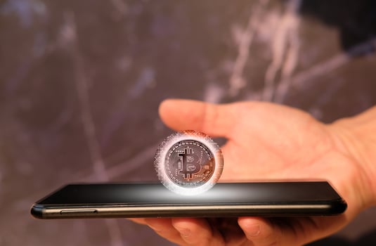 Bitcoin cryptocurrency coin and euro coin on smartphone, concept photo