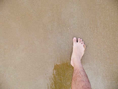 Male foot in the sand photo