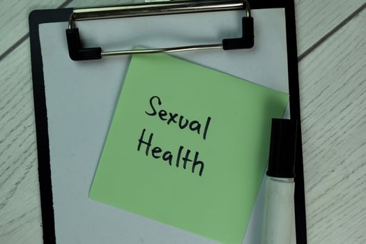 Sexual health written on notepad isolated on wooden table photo