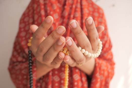 Close up of hands praying with beads photo