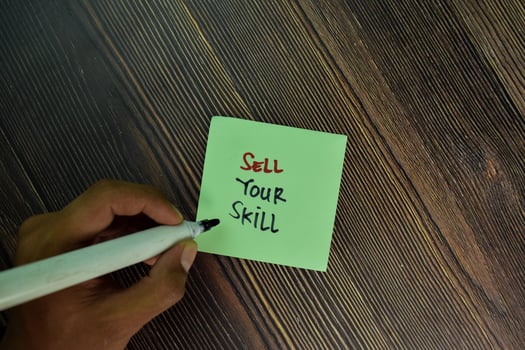 Sell your skill written on sticky notes isolated on wooden table photo