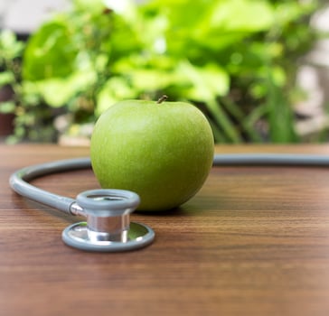 Green apple with a stethoscope, health concept photo