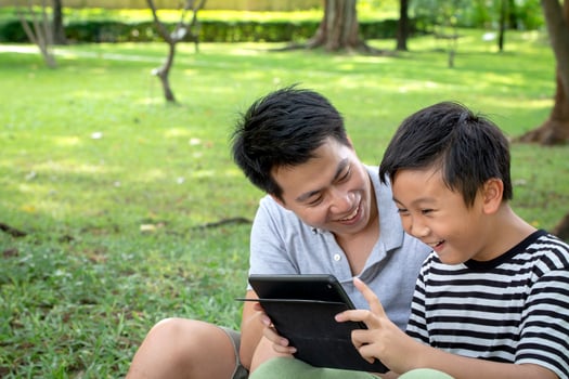 Father and son using a tablet outside photo
