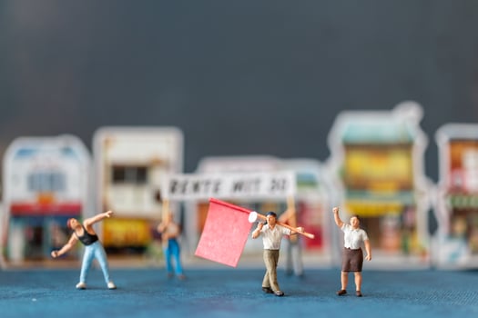 Miniature people, protesters holding signs, raising their hands for revolution, protesting concept photo
