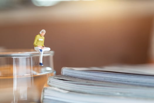 Miniature woman wearing headphones and listening to music on a smartphone photo