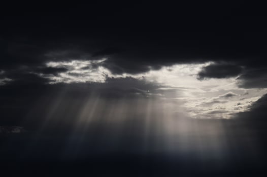 Crepuscular rays through dark cloudy skies photo
