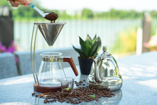 Barista pouring coffee powder into the drip cone photo