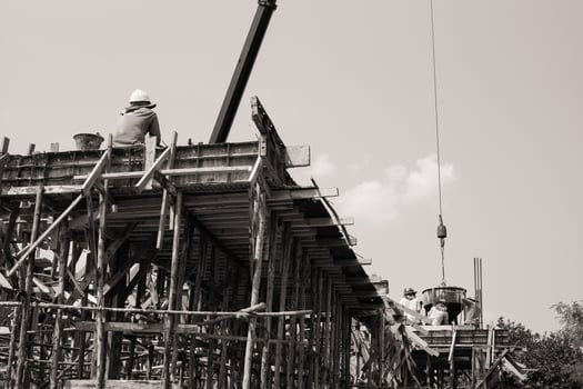 Monochrome of workers carrying the cement container to pour at site photo