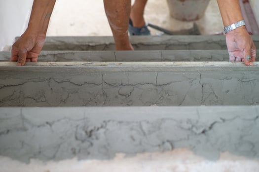 Closeup hands of worker works with trowel in plastered cement floor photo