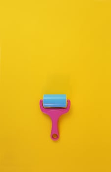Paint roller against clean yellow background with copy space for text message. Conceptual image. photo