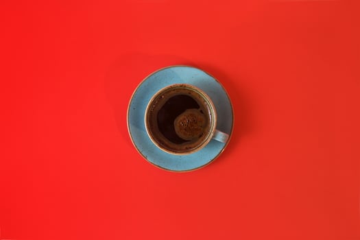 Coffee cup isolated on red background with copy space. Top view of strong morning coffee. photo