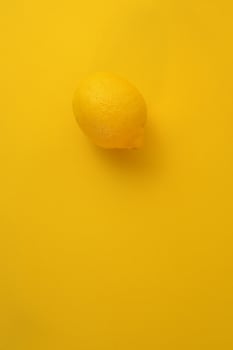 Yellow lemon isolated on clean yellow background. Abstract minimal concept. photo
