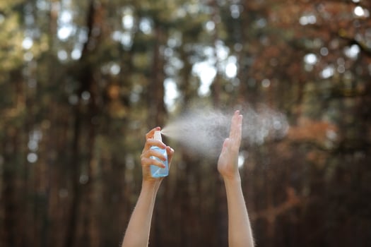 Women hands applying alcohol spray or anti-bacteria spray outdoor to prevent the spread of germs, bacteria, and virus, quarantine time, focus on close up hands. Coronavirus. Copy space. photo