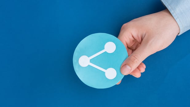 Male hand holding sharing shape symbol, on blue background. photo