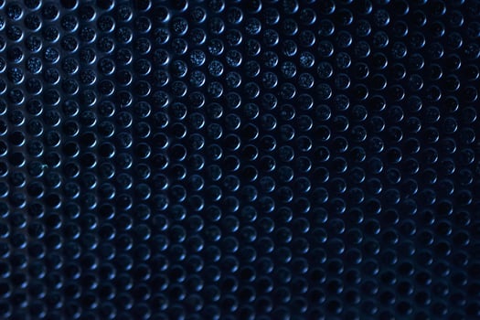 Black background made of iron grating with small round holes photo