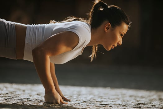 Young woman doing puhsups on the street photo