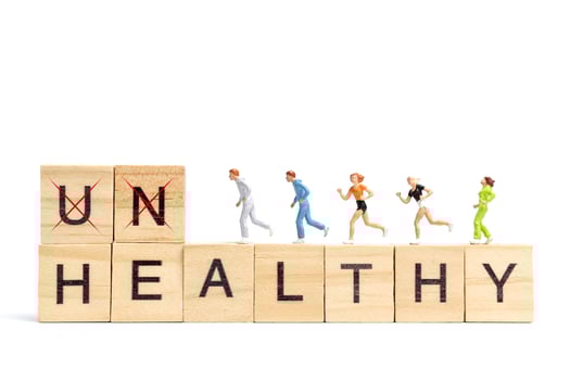 Miniature people running on wooden letter block on white background photo