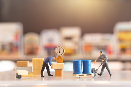 Miniature people, postman officers on duty preparing to send a box to the consumer. Delivery service for e-commerce concept photo