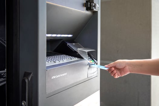 Close up of female hand using credit card at an ATM machine to withdraw money photo