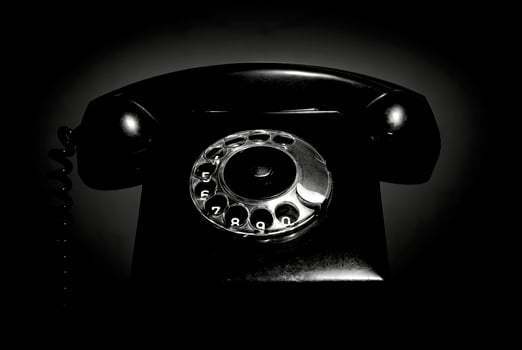Vintage landline telephone with a handset in black and white. Retro dial phone in a low key. photo