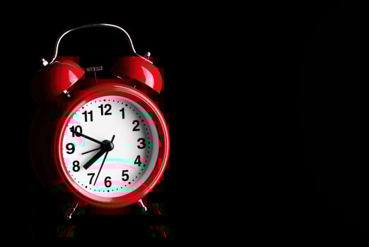 Red alarm clock on black background photo