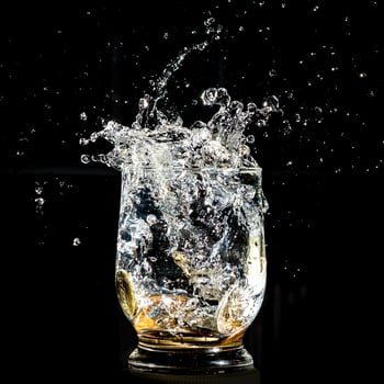 Coins falling splashing into a water glass photo