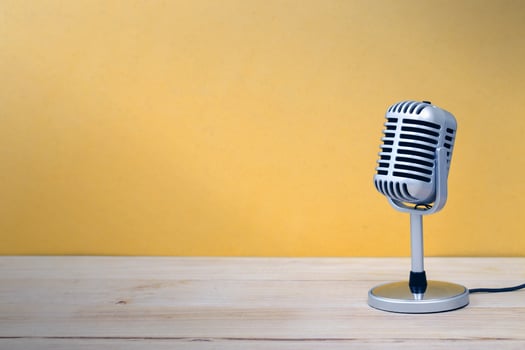 Vintage microphone isolated on wooden and yellow background photo