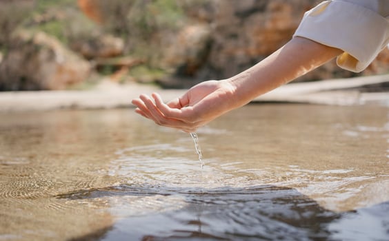Woman dipping hand in ocean water photo
