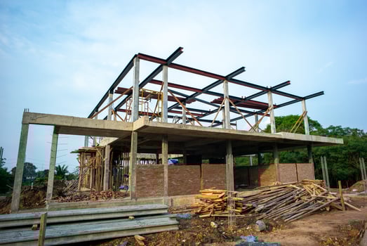 A house structure under construction at a site with a blue sky background photo