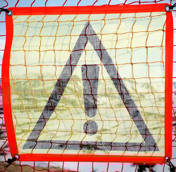 A yellow prohibition sign on a plastic net photo