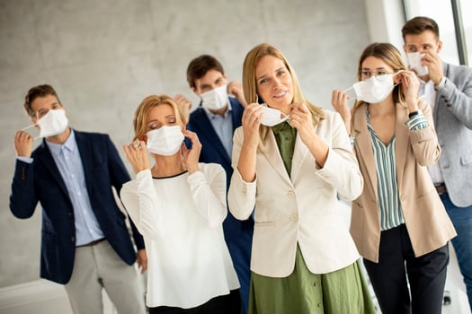 Group of professionals putting on masks photo