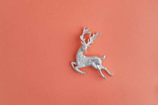 Beautiful Christmas silver deer close-up isolated on a peach background photo