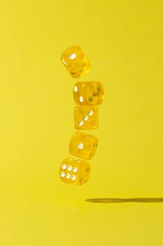 Falling yellow dice on yellow background photo