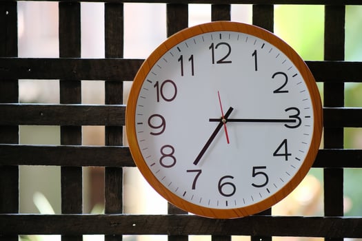 Wall clock on wood background and time concept photo