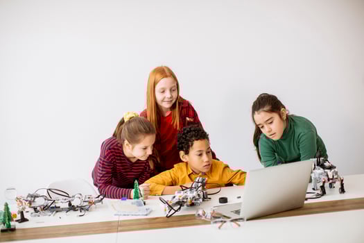Happy kids programming electric toys and robots at robotics classroom photo