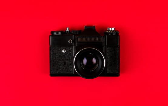 Flat lay film camera isolated on red background photo